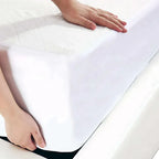 Person holding a white mattress protector with hands visible
