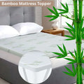 Bamboo mattress topper on a bed with bamboo plant and 'Bambu' branding.