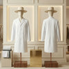 Two mannequins wearing white lab coats and hats in a stylish interior setting.