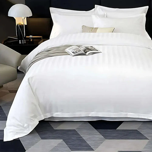 White bedding set on a bed with a magazine, in a bedroom setting.