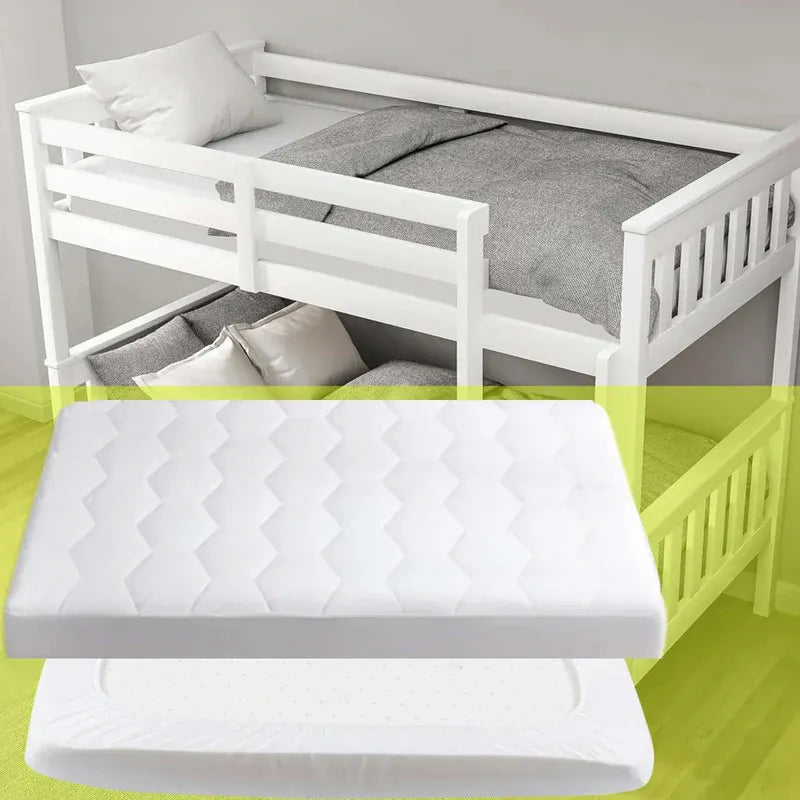 White bunk bed with a mattress on a green floor