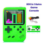 Green retro game console with screen displaying a game, cable, and reflection on a white background.
