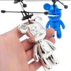 Silver and blue toy figures with propellers held by a hand on a white background