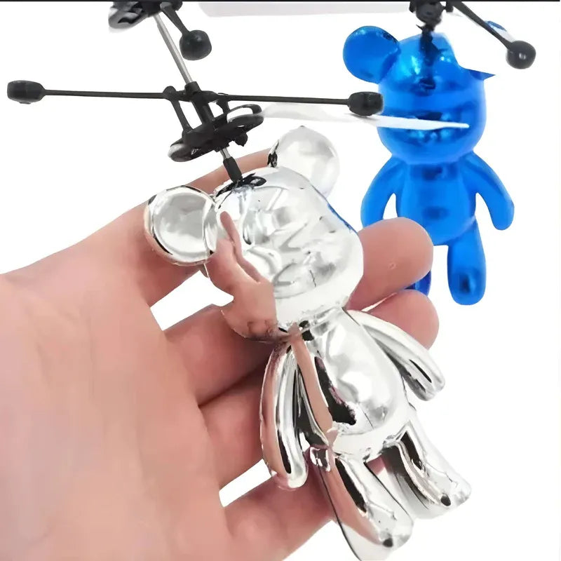 Silver and blue toy figures with propellers held by a hand on a white background