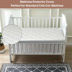 White crib with mattress protector cover on a wooden floor.