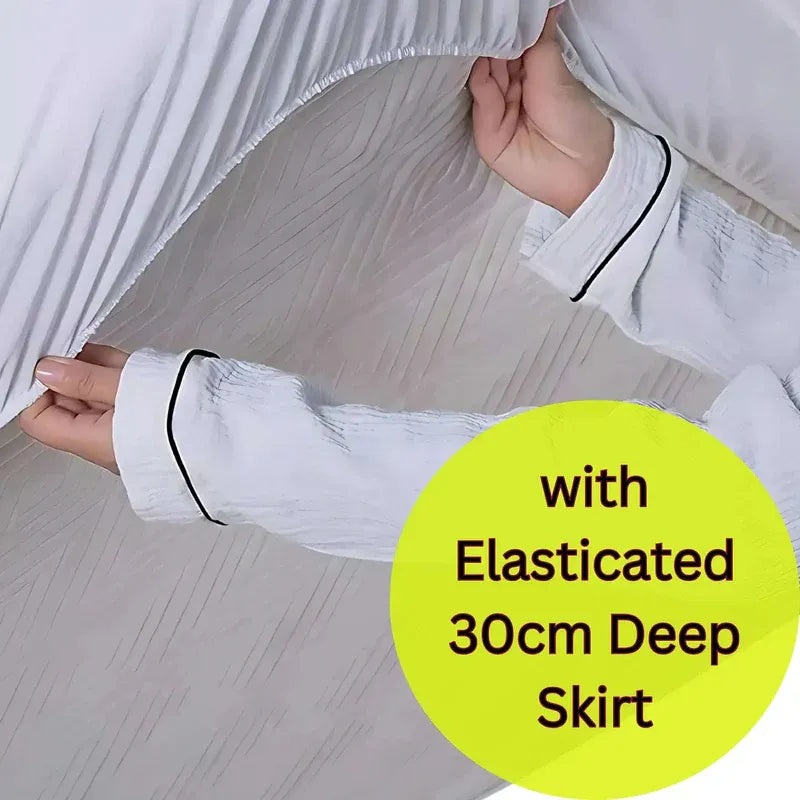 White blouse with black trim held up to show elasticated skirt, on a light background.