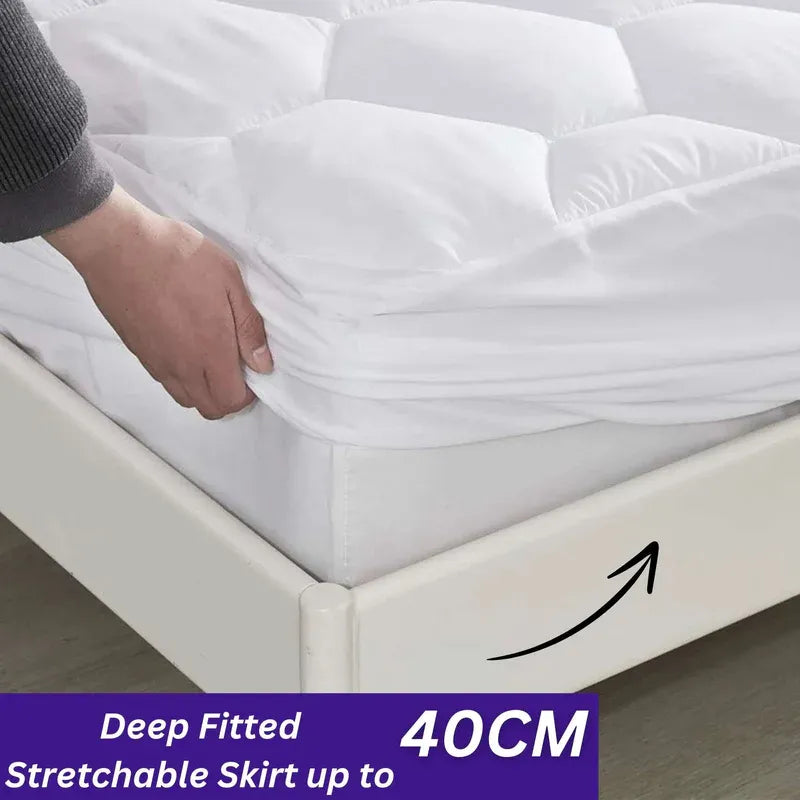 Person adjusting a white mattress cover on a bed with text indicating deep fitted and stretchable skirt up to 40CM.