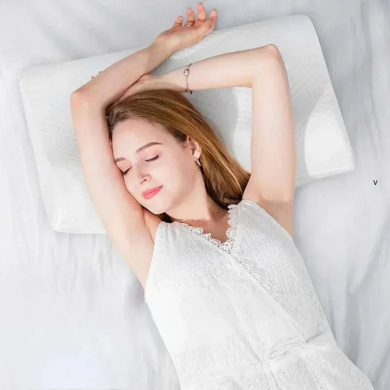 Woman lying on a white pillow with a white blanket, eyes closed.