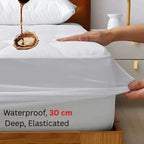 Bedding set with a waterproof mattress protector being stretched over a bed.