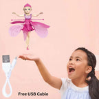 Child holding a USB cable with a fairy doll above, on a pink background