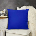 Blue pillow on a white chair with a gray wall and decorative items in the background