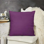 Purple pillow on a white chair with a dark gray wall and decorative items in the background