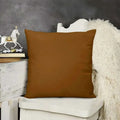 Brown pillow on a white chair with a dark gray wall and decorative items in the background