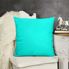 Turquoise pillow on a white chair with a decorative horse figure in the background.