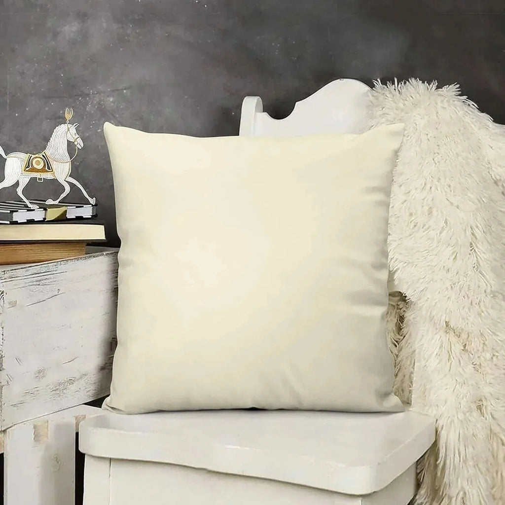 Beige pillow on a white chair with a dark gray wall and decorative items in the background