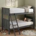 A dark gray wooden bunk bed with a built-in ladder, styled with white mattresses, gray pillows, and a small plush toy in a child's bedroom.