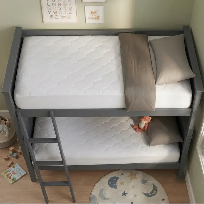A gray wooden twin-over-twin bunk bed with a ladder, shown with two white mattresses, beige pillows, and a folded beige blanket in a child's bedroom.